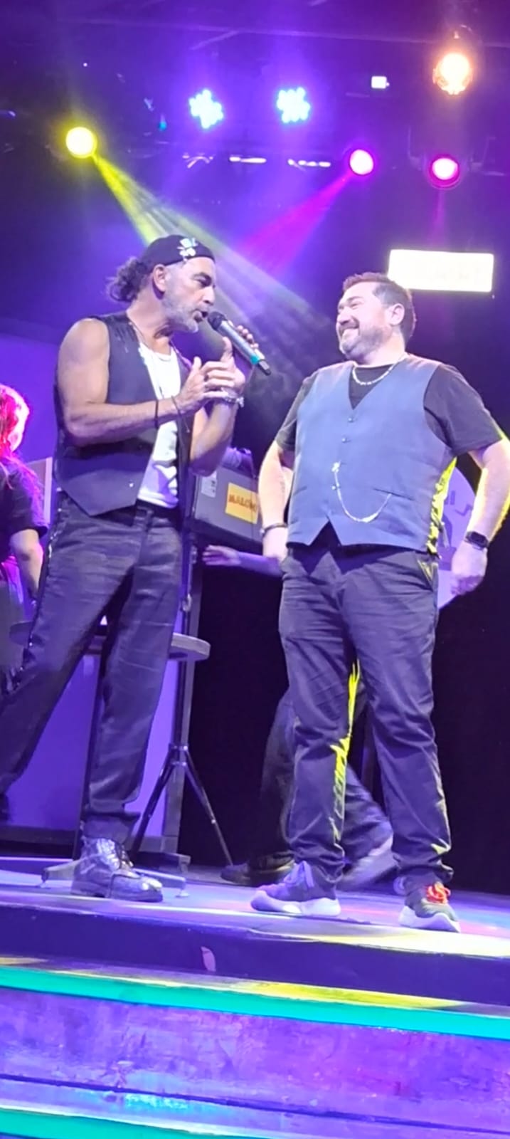 Leo Pérez con otro comediante en escenario con luces